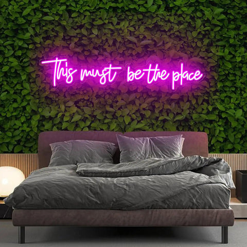 Pink 25x11 Inch Neon Sign LED Neon Lights For Bedroom Wall Decor "This Must Be The Place" above a bed with green wall