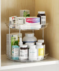 Two-tier clear acrylic Lazy Susan organizer with chrome supports, installed in cabinet, 9.25 in, holding medicine bottles