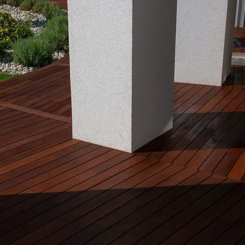 Heavy Duty Liquid Waterproofing Membrane Multi Surface Crack And Leak Repair Coating Interior Exterior Water Based Moisture Blocker Heavy Duty Sealant Easy Brush Application 5 Gallon Sandy Beige applied on wooden deck surface with white columns.