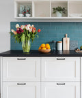 White kitchen cabinets with 10 pack 5 inch matte black cabinet handles made from solid zinc alloy, featuring modern decor and a vase with flowers.