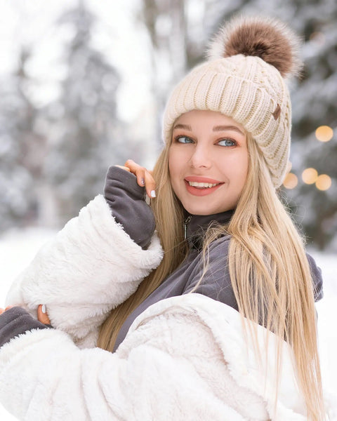 Woman wearing Cozy Winter Beanie Knit Hat For Women Warm Fleece Lined With Faux Fur Pom Poms Thick Ski Skull Cap Beige