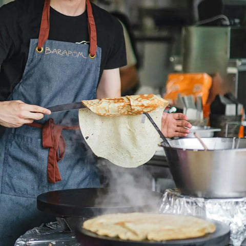 Person using Must Have Pro Grade Crepe Spreader And Spatula Kit Set 12 Inch Curved Offset Spatula in kitchen over pan