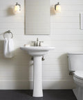 Bancroft Single Sconce With Frosted Glass Shade, Brushed Nickel Finish flanking a bathroom mirror, adjustable light