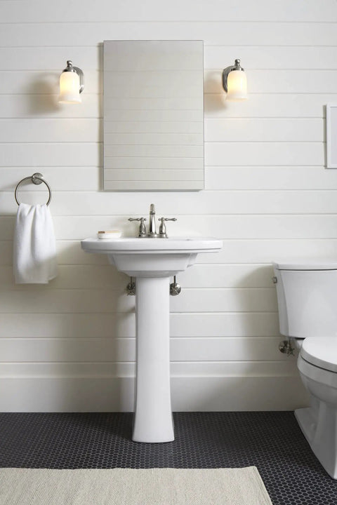 Bancroft Single Sconce With Frosted Glass Shade, Brushed Nickel Finish flanking a bathroom mirror, adjustable light
