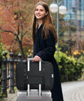 Woman with Foldable Travel Duffel Bag 30L Fits Underseat Personal Item 18x14x8 for Women and Men using luggage handle