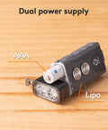 EDC Keychain Flashlight with dual power AAA battery and LiPo system, showcasing compact design on wooden surface.
