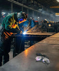 Heavy Duty Wrap Around Safety Glasses For Welding And Grinding With Impact Resistant Polycarbonate Lenses on a workbench in a welding shop.