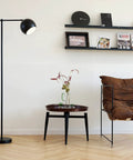 Living room with Molly Floor Lamp In Matte Black With Dope Modern Transitional Design Sleek Ambient Lighting Statement Piece For Living Rooms Contemporary Floor Lamp With Easy Assembly And Versatile Style next to a brown chair and round table.