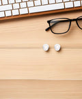 Push In Silicone Nose Pads For Glasses 50 Pack Non Slip Waterdrop Cushions Transparent Anti Sweat Replacement Inserts on wooden desk.