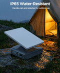 High Capacity 288Wh LiFePO4 Portable Power Station With Stand And Carry Case in rain by tent, showcasing IP65 water-resistance.