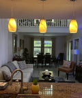 Three Pack Indoor Mini Pendant Lights For Kitchen Island In Polished Nickel With Hand Blown Orange Glass Shades 4.75 Inch Fully Dimmable UL Listed Sweet Bar Counter Dining Room Accent Lighting hanging over a kitchen island, illuminating a modern living space.