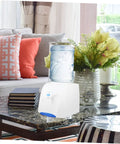Compact Desktop Cold Water Dispenser With Easy Press Button Operation displayed on a coffee table in a living room setting