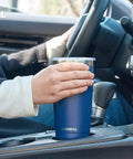 Person holding 20 Oz Travel Coffee Tumbler Insulated Stainless Steel Cup With Lid in car, navy blue powder coated, double wall vacuum