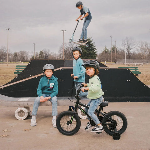 Children at a skatepark, one on a 16 Inch Kids Bike For Ages 4 And Up, BMX Style Youth Bicycle With Training Wheels, Coaster Brake.