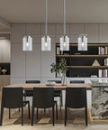 Elegant dining room with Four Light Brushed Nickel Island Pendant Lights With Clear Glass Shades For Kitchen Island glowing warmly.