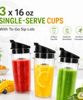 Three 16 oz single-serve cups with black sip lids filled with red, yellow, green smoothies alongside fruits on a countertop.