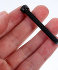 Person holding Heavy Duty M5x50mm Hex Socket Head Screw, black oxide finish, machine thread for industrial use, close-up view.