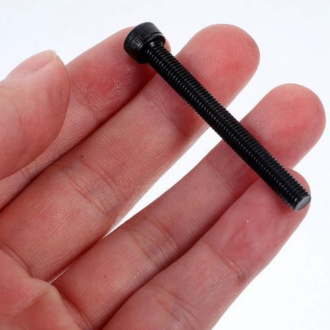 Hand holding M5x50mm Hex Socket Head Screws Fully Threaded Steel Bolts With Black Oxide Finish For Industrial And Furniture Mounting