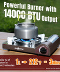 14,000 BTU Portable Butane Camping Stove with kettle, piezo ignition, brass burner, wind guard on wooden table outdoors.