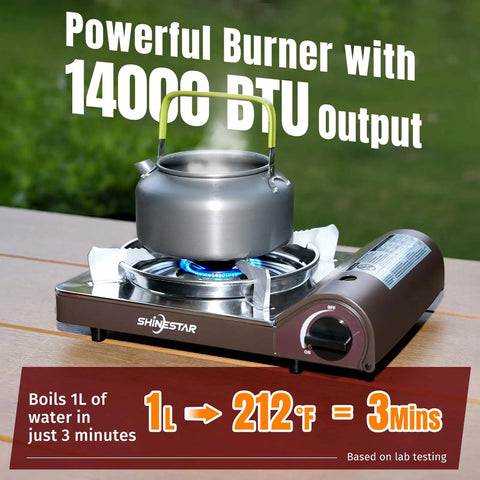 14,000 BTU Portable Butane Camping Stove with kettle, piezo ignition, brass burner, wind guard on wooden table outdoors.