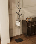 Tree Shaped Coat Rack With Eight Hooks Heavy Duty Freestanding Metal Coat Tree On Cast Iron Base next to a cabinet