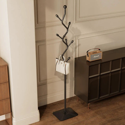 Tree Shaped Coat Rack With Eight Hooks Heavy Duty Freestanding Metal Coat Tree On Cast Iron Base next to a cabinet