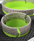 Close-up of Porcelain Tile Diamond Core Drill Bit Set and Hole Saw Kit, textured edge detail, green interior on black mat.
