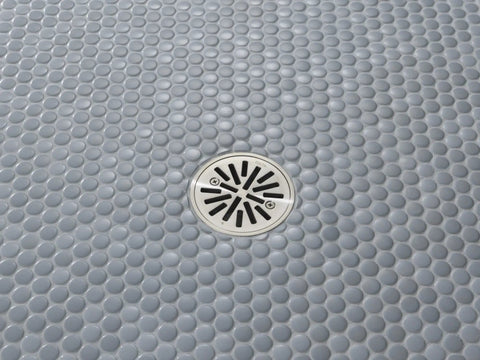 Smooth Operator 4 Inch Brushed Nickel Shower Floor Drain For Tile Installations, round strainer grate on pebble tile floor.