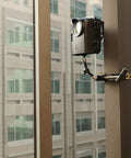Hella Rugged Construction Time Lapse Camera Bundle With 1080p Waterproof Housing mounted on a window with a clamping setup.