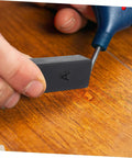 Hand using Floor Repair Kit With Quick Heating Wax Block Sponge For Laminate And Hardwood Floors And Tile Scratches Easy To Use Home Damage Fix Durable Tool For Home Renovation And Quick Restore.