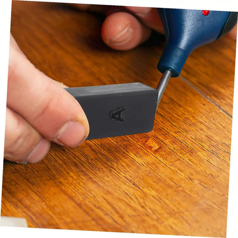 Hand using Floor Repair Kit With Quick Heating Wax Block Sponge For Laminate And Hardwood Floors And Tile Scratches Easy To Use Home Damage Fix Durable Tool For Home Renovation And Quick Restore.
