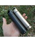 Hand holding two Portable Survival Waterproof Pill Container For Outdoor EDC Gear, CNC Machined Aluminum Bottles, shown in silver and black.