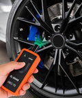 TPMS Relearn Tool For GM Tire Sensor And TPMS System Relearn Kit Reset Programming Device in use on tire sensor
