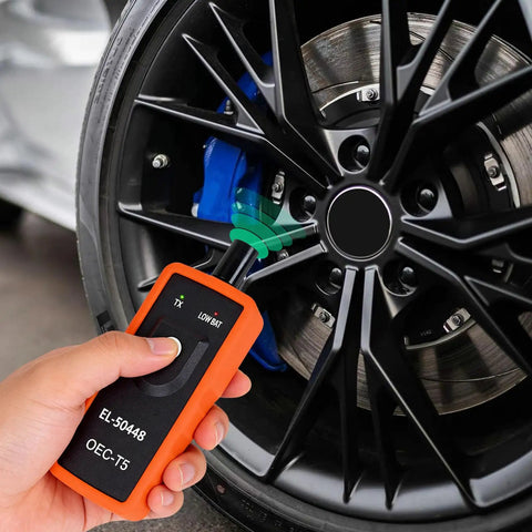 TPMS Relearn Tool For GM Tire Sensor And TPMS System Relearn Kit Reset Programming Device in use on tire sensor