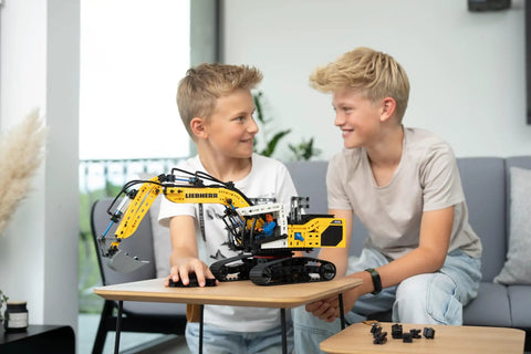 Liebherr R938 Pneumatic Excavator Kit 689 Piece Realistic Builder Model With Pneumatic System Manual Valves And Flow Regulators Ideal For Gearheads 10 And Up Great For Kids Teens And Adults Who Love Engineering. boys playing with assembled pneumatic excavator model