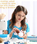 No Fuss Bulk Travel Sewing Crate Featuring Nifty Mini Repair Packs, with woman sewing using mini kit essentials.