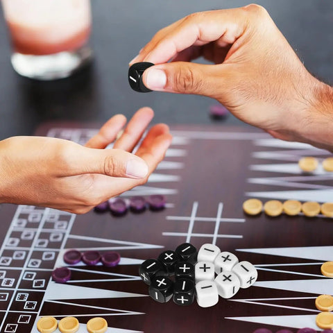 Hands holding a black die from 24 Piece Addition Subtraction Dice Set For Classroom Math Practice With 16mm Black And White Acrylic Symbols