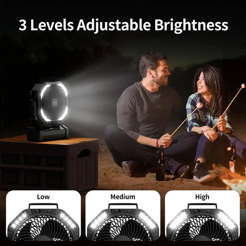 Camping Fan With Light 20000mAh Rechargeable Battery illuminating a couple by the campfire with adjustable brightness settings.