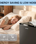 No Fuss And Slick Effortless Setup 30 Cubic Foot Upright Freezer Featuring A Reversible Door Built For Dorm Rooms Tiny Apartments And Home Workspaces In Matte Black Finish next to a sleeping person.