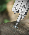 Close-up of Everyday Carry Ready Eighteen In One Stainless Steel Multitool Pliers with a screw bit on wood surface