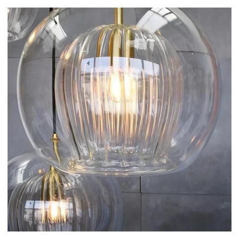 Close-up of Modern Simple Dining Room Pendant Light Creative Personality Bar Caffee Glass Lamp with golden fixture.