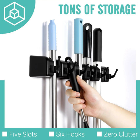 User organizing cleaning tools on wall mounted broom and mop organizer with five ball slots and six hooks, easy install, durable ABS.