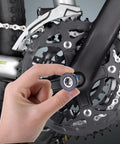Hand holding Stainless Steel 8mm Hex Bike Crank Arm Bolt near bike crankset for crank fixes and headset replacement.
