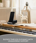 Sturdy Piano Phone Stand For Desk And Bedside Holder That Grips Up To 8 Cm Wide Phones, shown on piano beside decor and books.