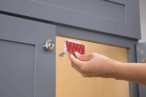 Person installing Eight Piece Adhesive Cabinet Latches in White, Easy Peel and Stick Install, No Tools Needed for Most Cabinets