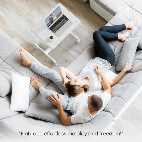 Overhead view of a couple relaxing on a sofa with a small standing desk on wheels with adjustable height, portable laptop PC table nearby.
