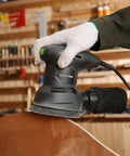 2.0 Amp Electric Random Orbital Sander with 6000 to 12000 RPM used on wooden surface in workshop setting