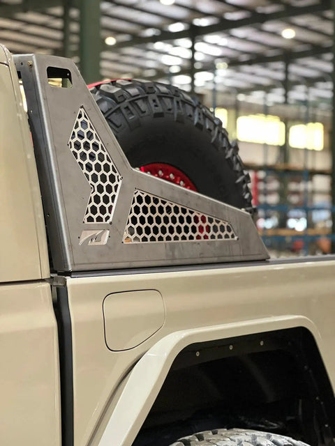 Side view of Chase Rack For Jeep Gladiator JT - Desert Inspired, Heavy Duty 11 Gauge HRPO Steel Rack with tire mounted, indoors.