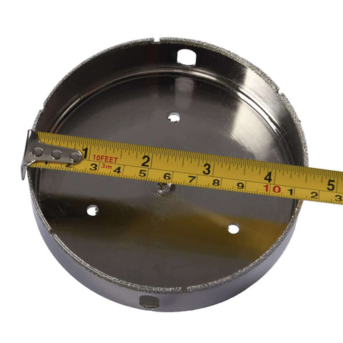 Drilax 4-1/2-inch diamond hole saw with guide; circular metal body with diamond edge and mounting holes, front view.