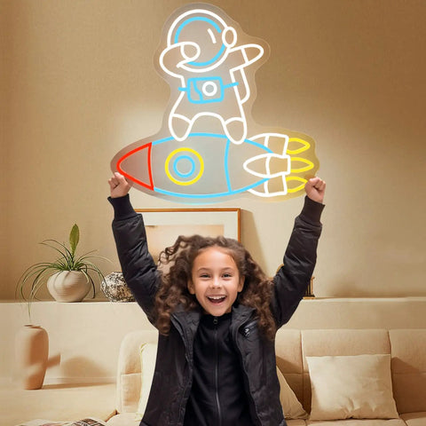 Child holding Dimmable Spaceman LED Neon Light With Transparent Backing Astronaut And Rockets Wall Art Space Room Decor